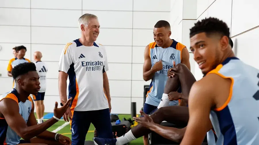 Kylian Mbappe receives advice from boss Carlo Ancelloti ahead of debut match.